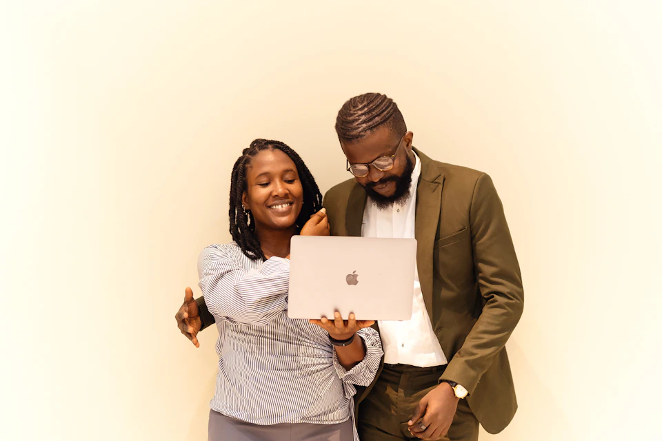 A mentor and a young leader looking at a laptop
