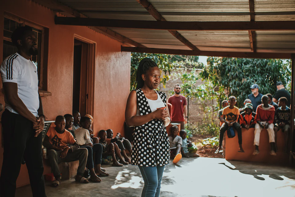 A facilitator teaching a group under a shelter